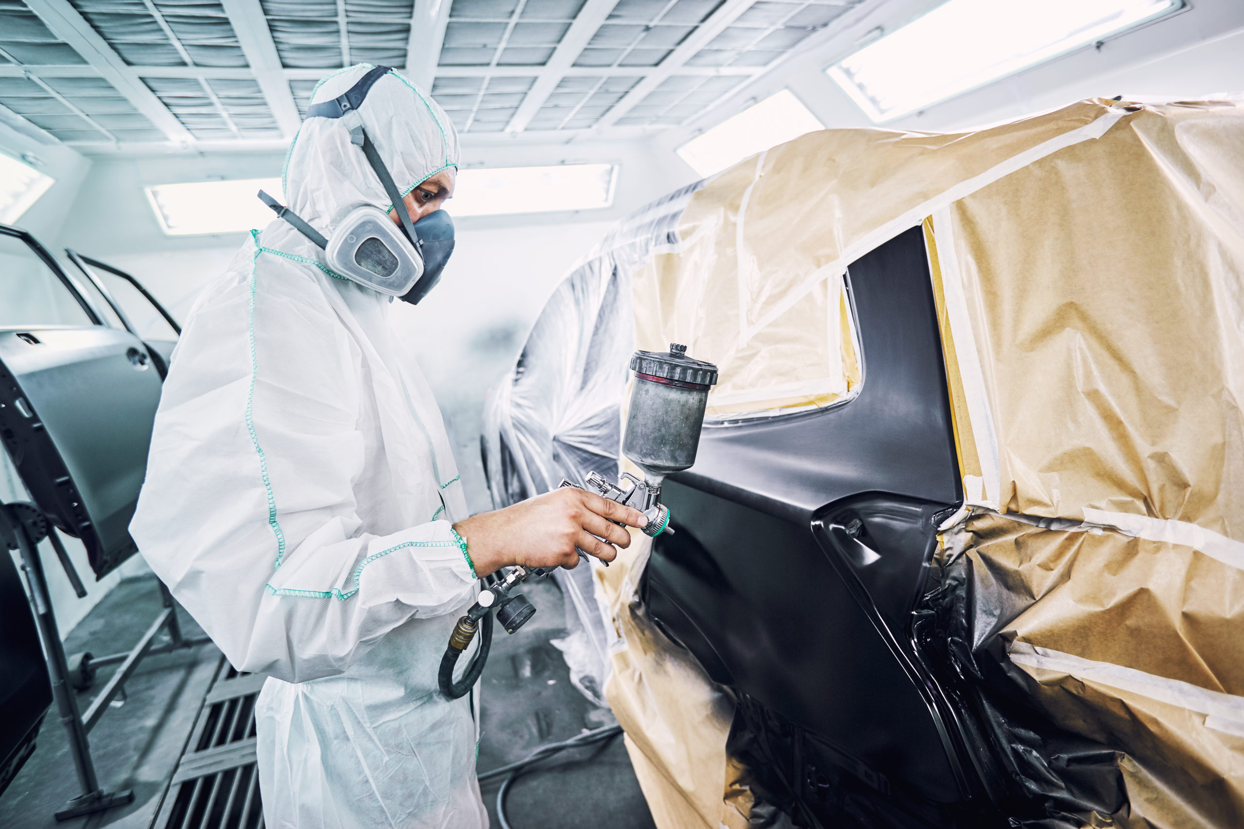 Painting the car in black color in the paint chamber on the service..